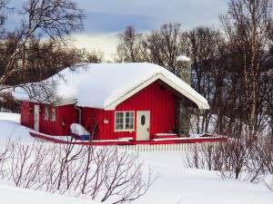Chalet rouge sous la neige en Laponie